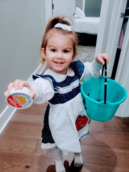 Aria shows off her teal pumpkin bucket and a cup of sunflower butter donated for the Spooktacular event.