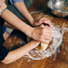Picture of an adult helping a child knead bread: Picture of an adult helping a child knead bread