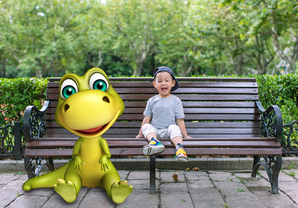 Boy sitting on a park bench next to a cartoon dinosaur